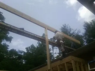 Carpenter setting a ridge beam over a new addition frame — Ice Dam Removal by Roofing Brothers in Parkville