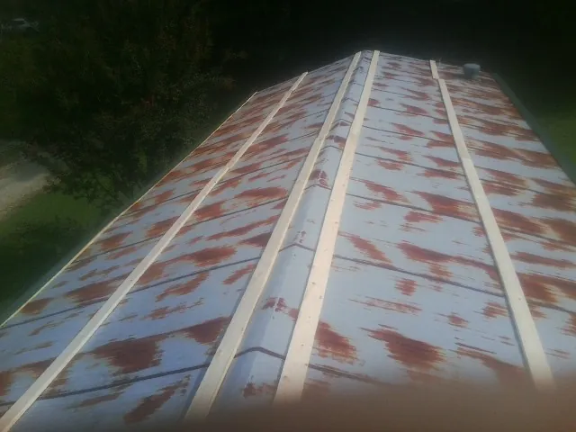 Rusted metal roof panels with new wood purlins before replacement — Storm Damage Roof Repair in Parkville by Roofing Brothers
