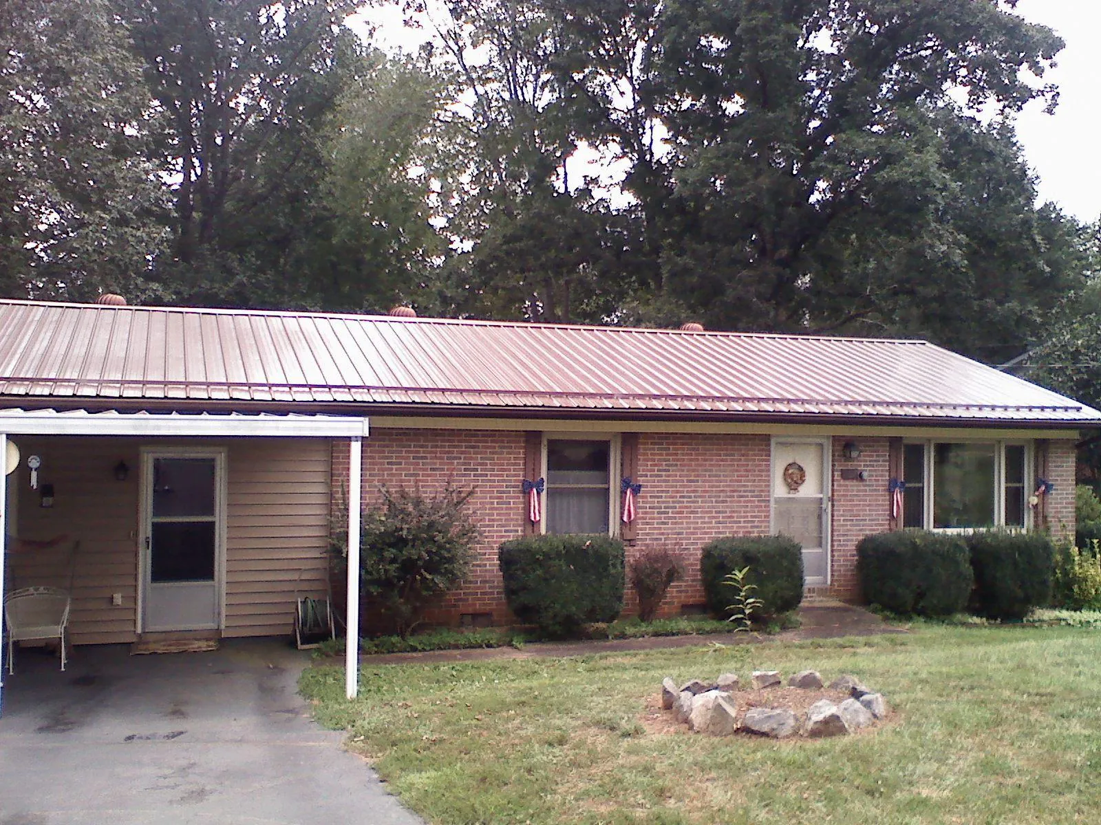 Bronze metal roof and carport on a brick ranch home — Roof Repair work by our crew in Parkville